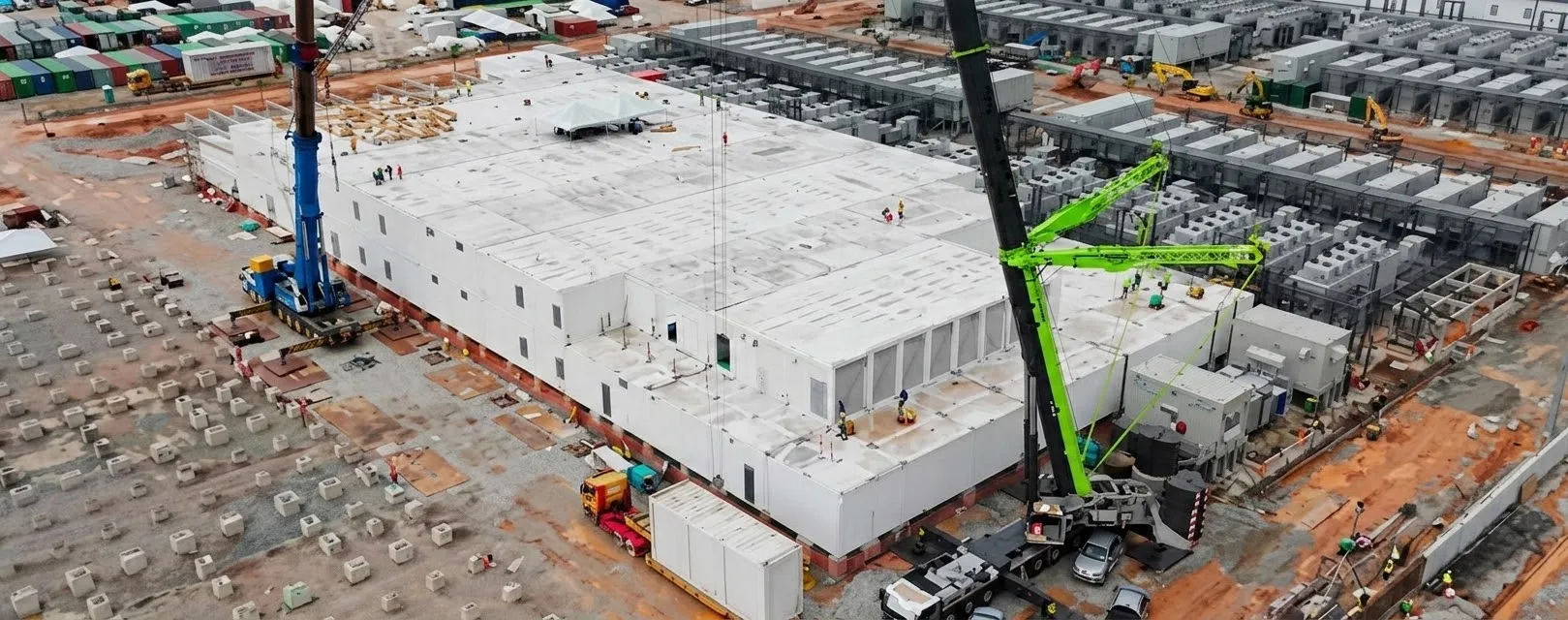 Cranes setting factory-built modules into place on site